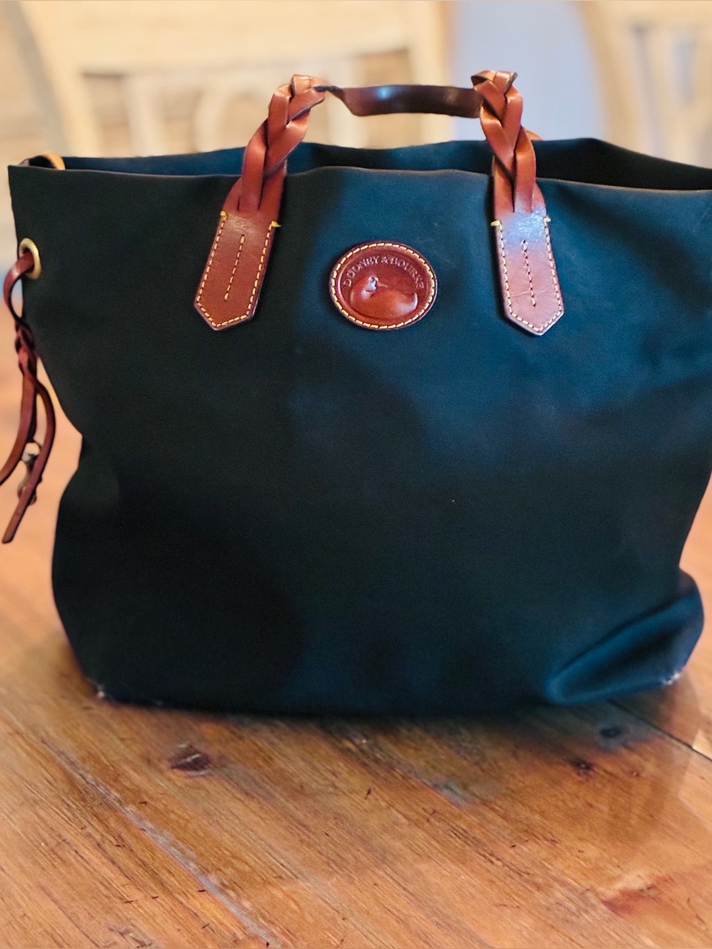 Dooney & Bourke black nylon shopper with leather handles and snaps.